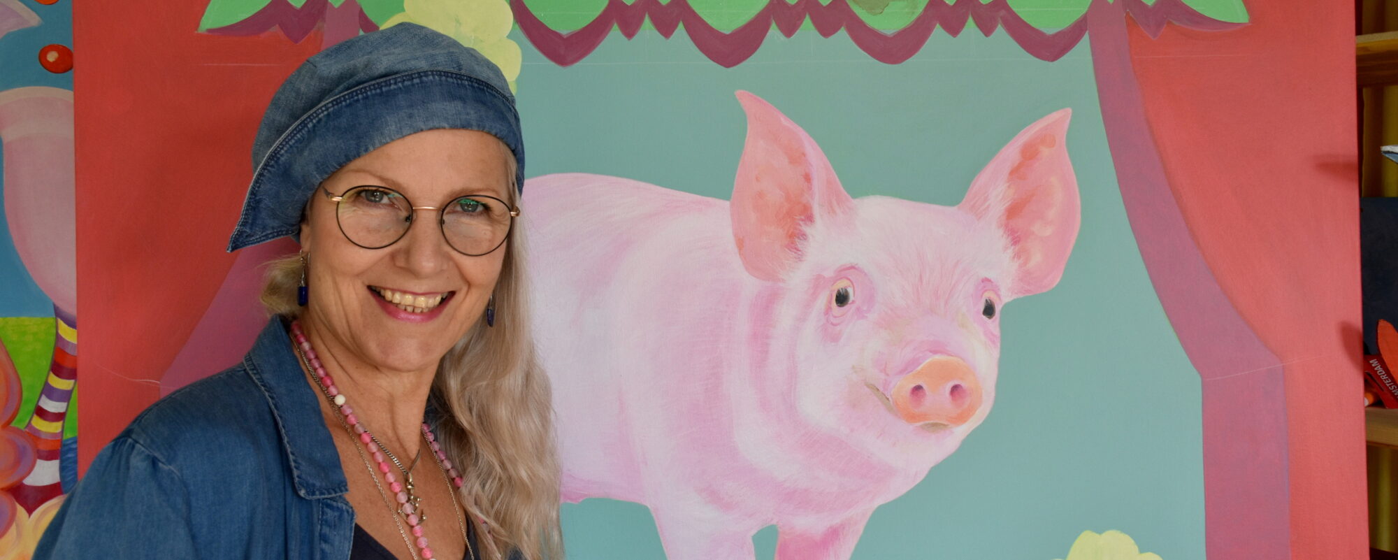 Biggi Hopp vor ihrem Gemälde Das rosa Schweinchen