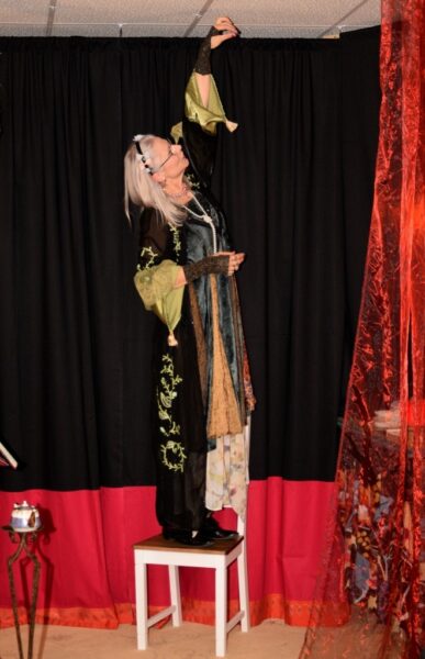 Biggi Hopp erzählt Teemärchen und steht auf einem Stuhl